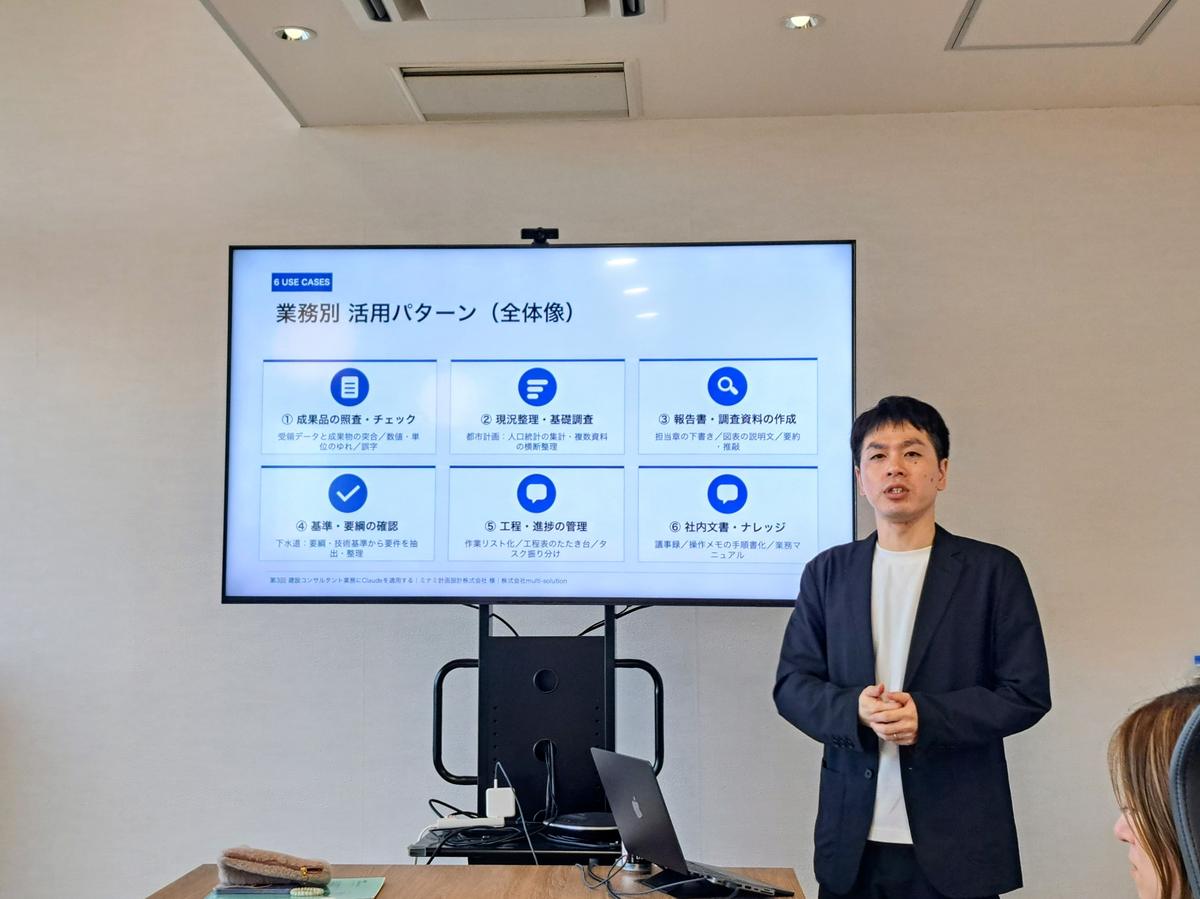 AI研修の様子：講師がモニターに映した業務別のAI活用パターンを解説している